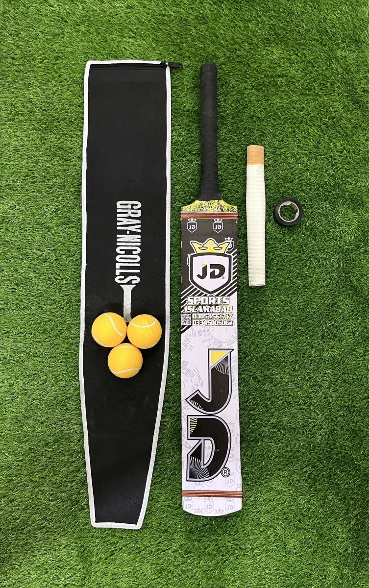 Cricket bat, ball, grip  and pouch on a green grass background