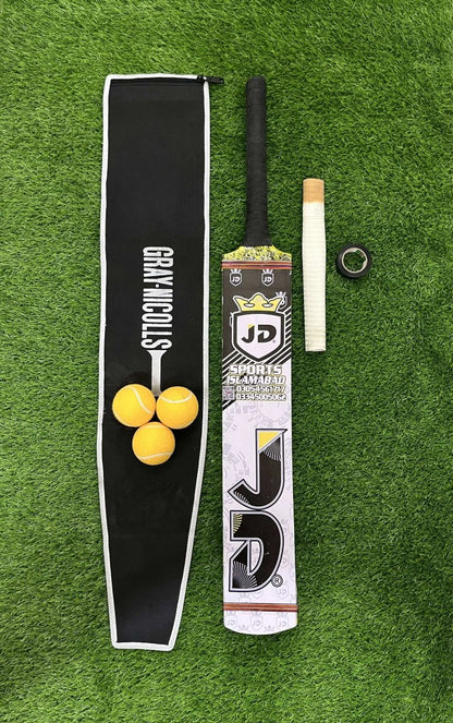 Cricket bat, ball, grip  and pouch on a green grass background